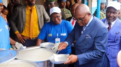 Prime Minister Felix Moloua serves some food. 