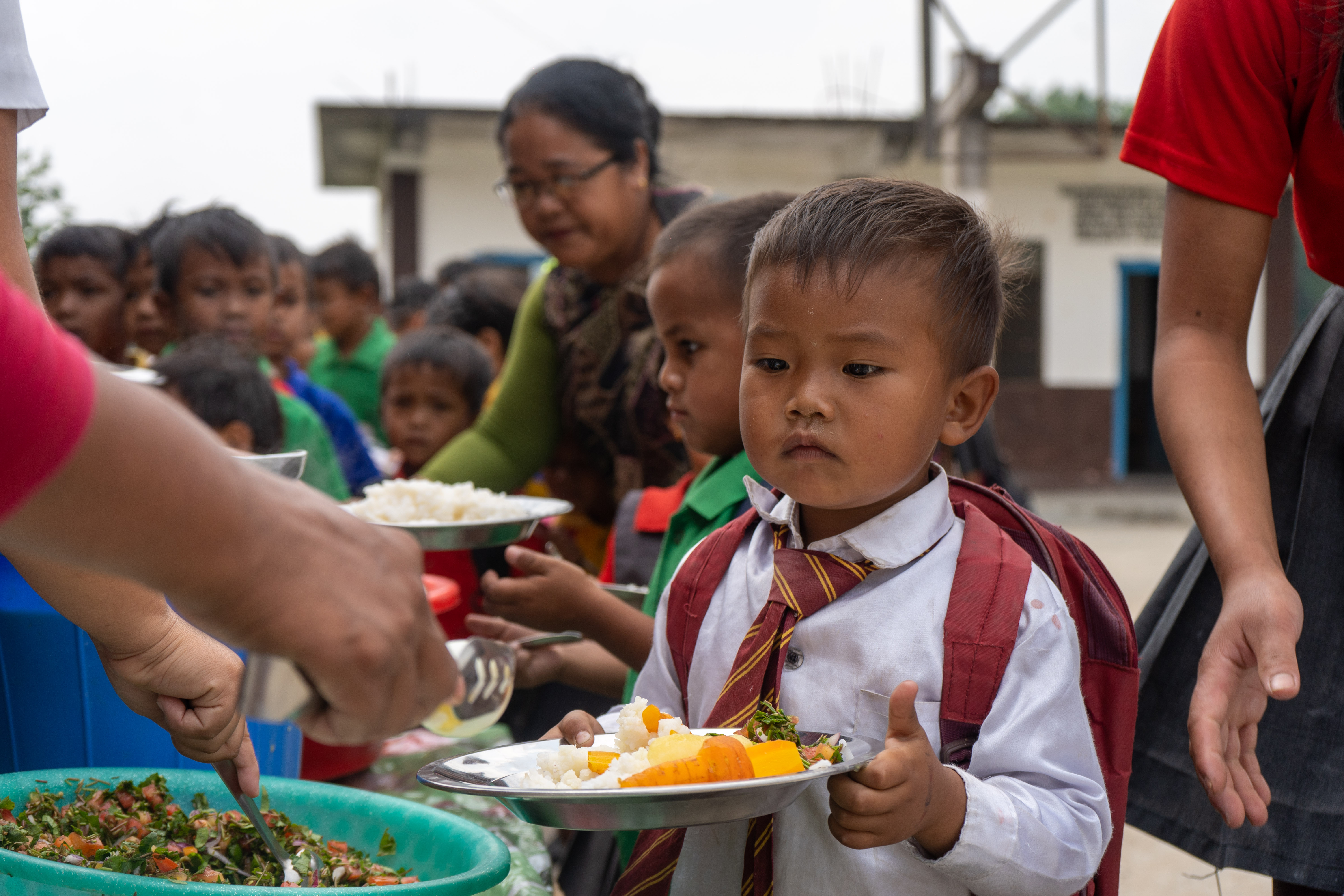 Children receiving their school meals in India