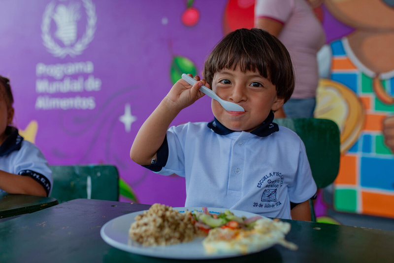Boy from Ecuador is happy to eat his school meal.