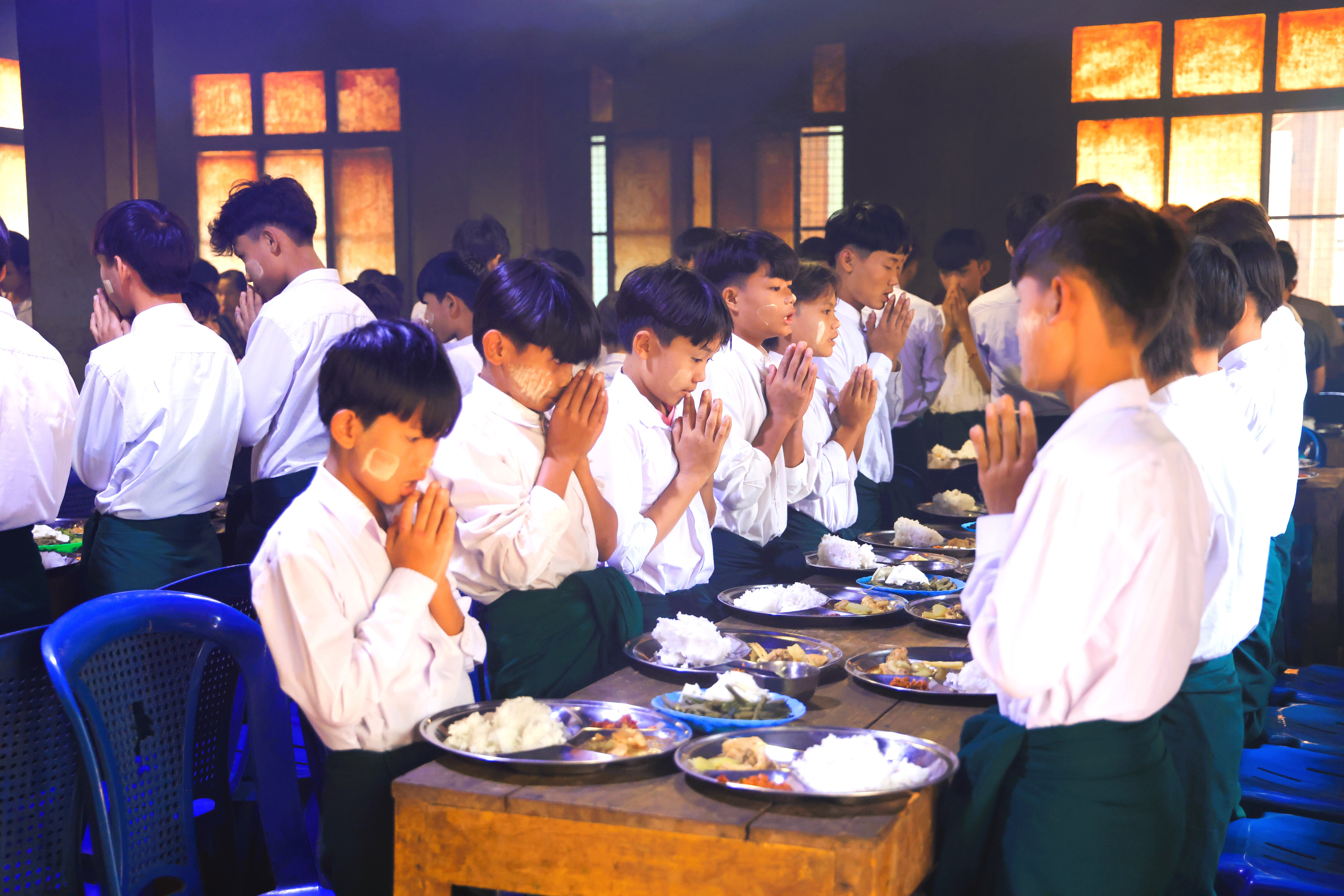 Prayer before school lunch meal in Myanmar