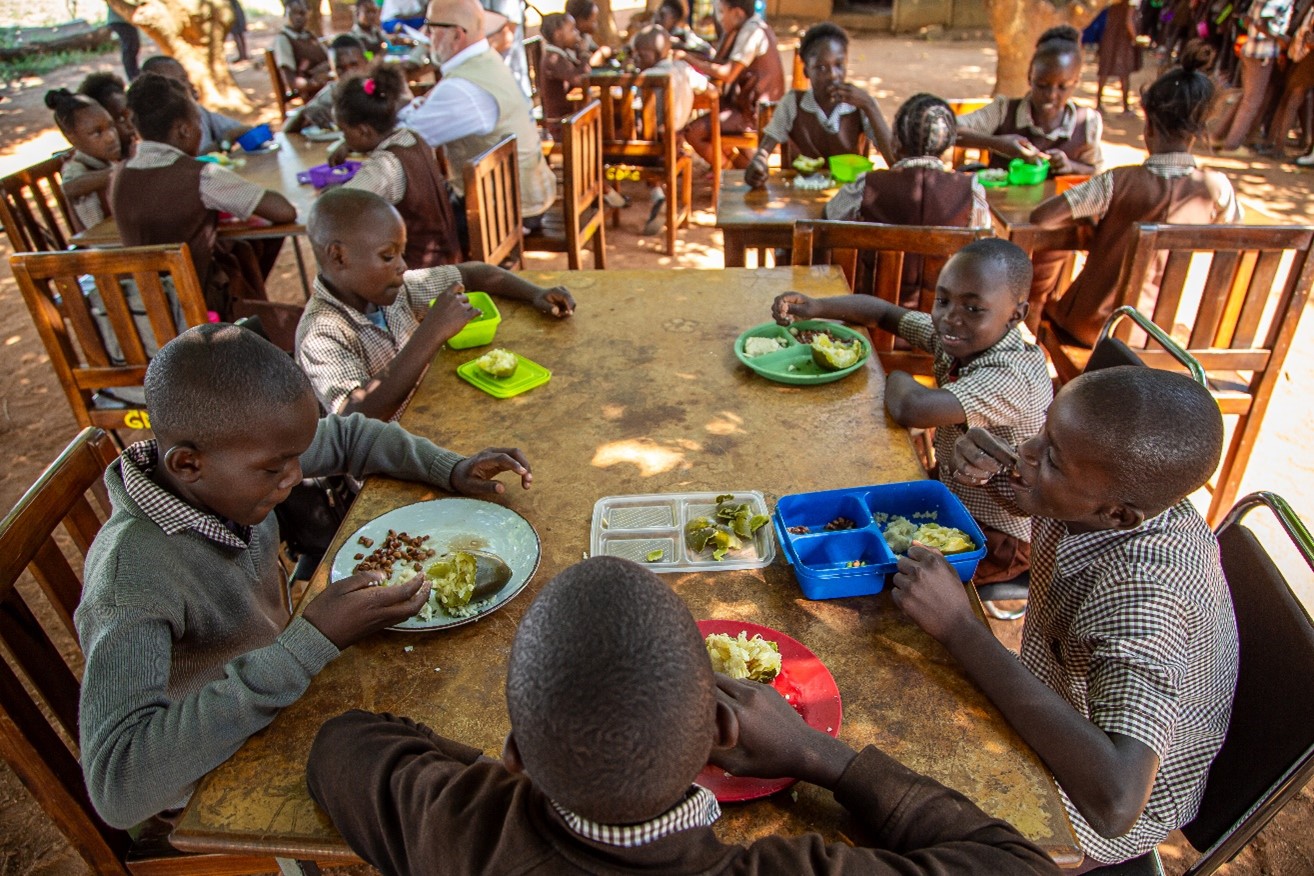 Learners at a school in Zambia enjoy their lunch meal of bean and vegetables.