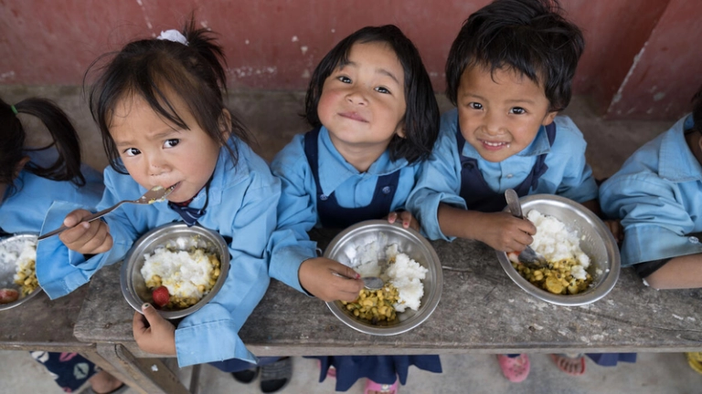 Children eating food at a school 