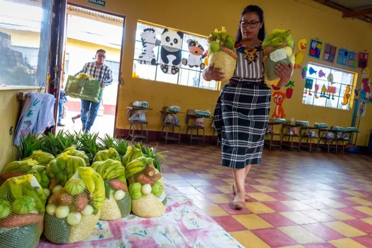 Woman with a variety of fruits and vegetables in a school room