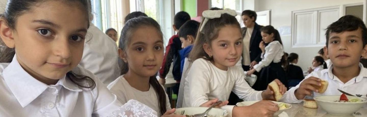 Children sitting at a table sharing a meal