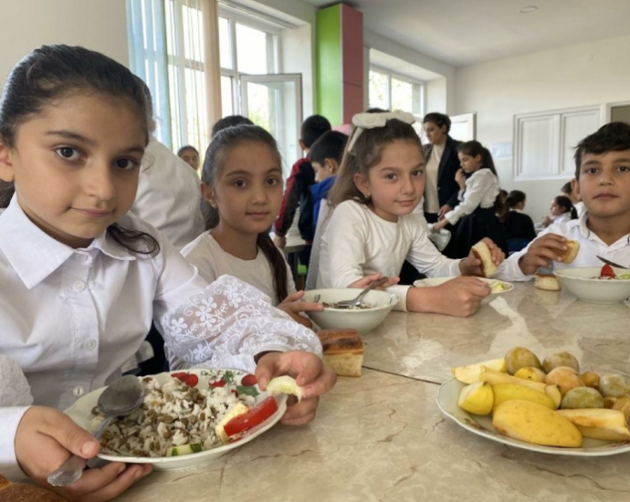 Children enjoying mealtime together at a table with plates of food