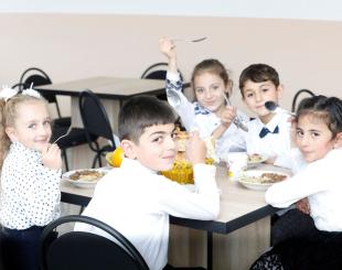 Children eating at a school cafeteria table