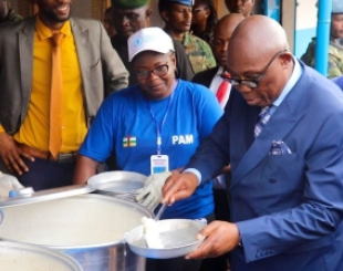 Prime Minister Felix Moloua serves meals.  