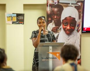 Mary Njeri speaking during a school meals event.