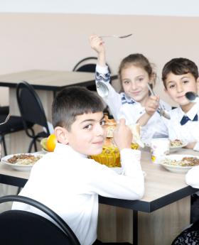 Children eating at a school cafeteria table