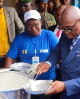 Prime Minister Felix Moloua serves meals.  