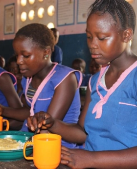 Three girls having their meals at school.