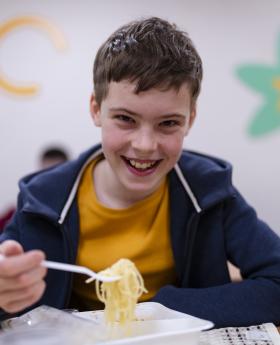 A young kid is eating his school meal in a school in Ukraine 