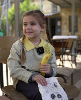 A student enjoying recess while carrying WFP’s daily school snack and fruit